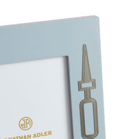 Metallic bookmark with a unique design on a light blue card, featuring the brand 'Jonathan Adler'.