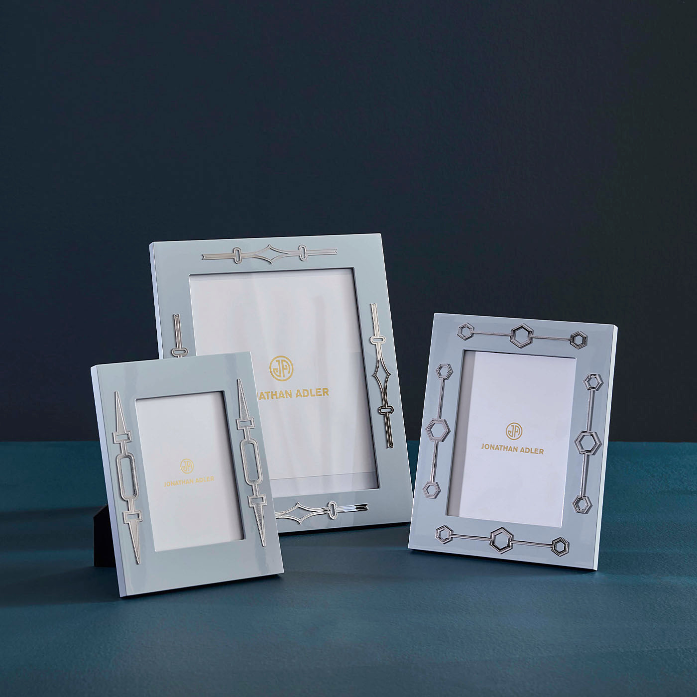 Three decorative photo frames on a dark surface with a dark background