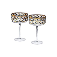 Two clear stemmed coupe glasses with a faceted geometric cut-glass pattern and gold trim, shown on a plain white background.